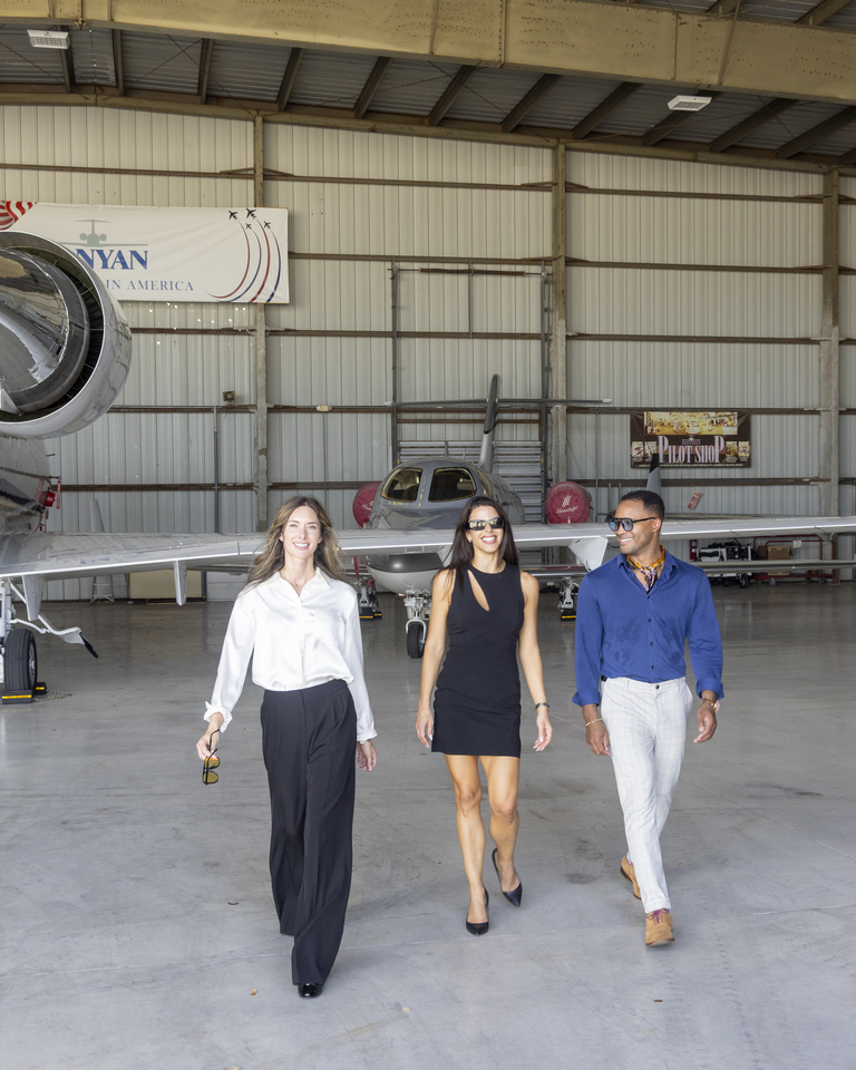 Three students walking through the hangar at Fort Lauderdale Executive Airport