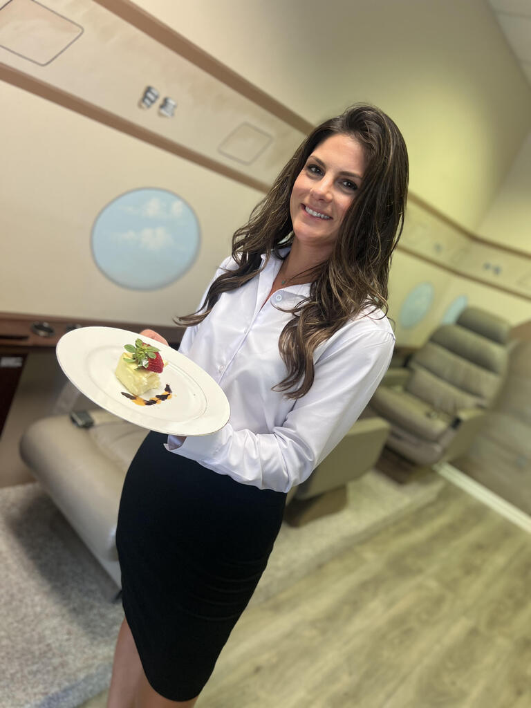 Student serving a plated meal in the mock cabin